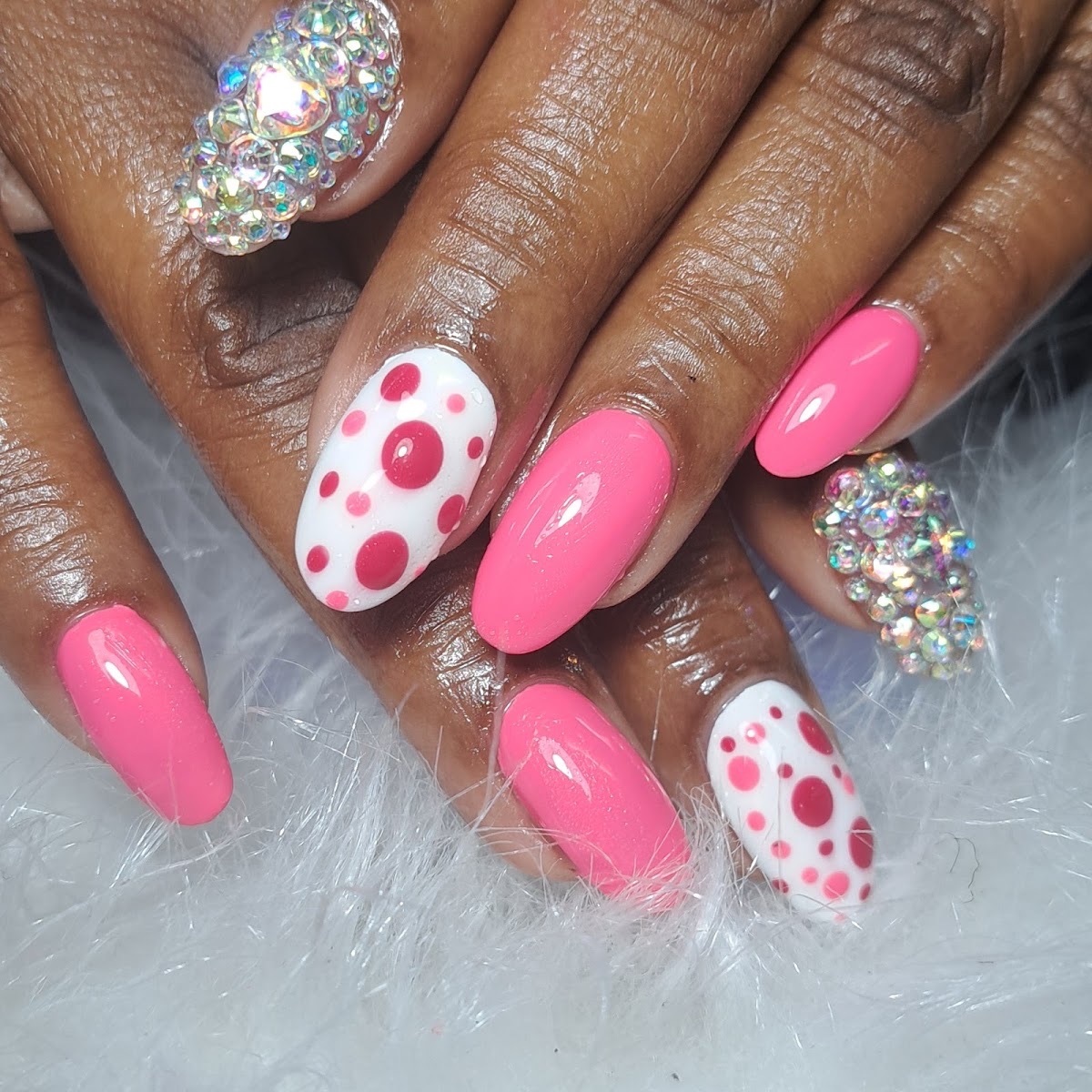 Hot-pink and white polka-dot nails with crystal-encrusted accent nails