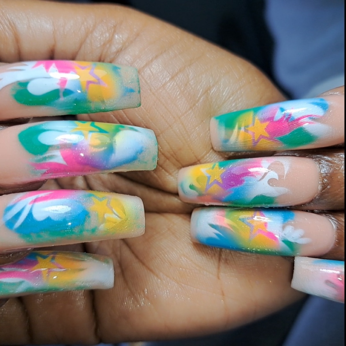 Long coffin nails with rainbow tie-dye and gold star nail art